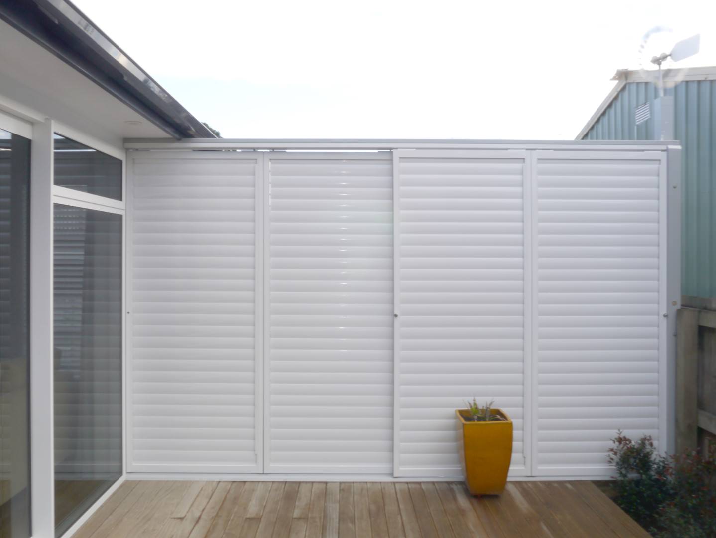 Closed outdoor shutters create a private backyard